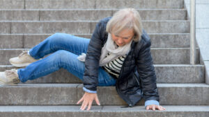 senior woman accidentaly falling down stone steps outdoors